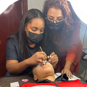 Aluna em curso prático de alongamento de cílios do Instituto Casa Esperança.