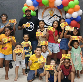 Crianças do Instituto Casa Esperança segurando Caixas de bombom.